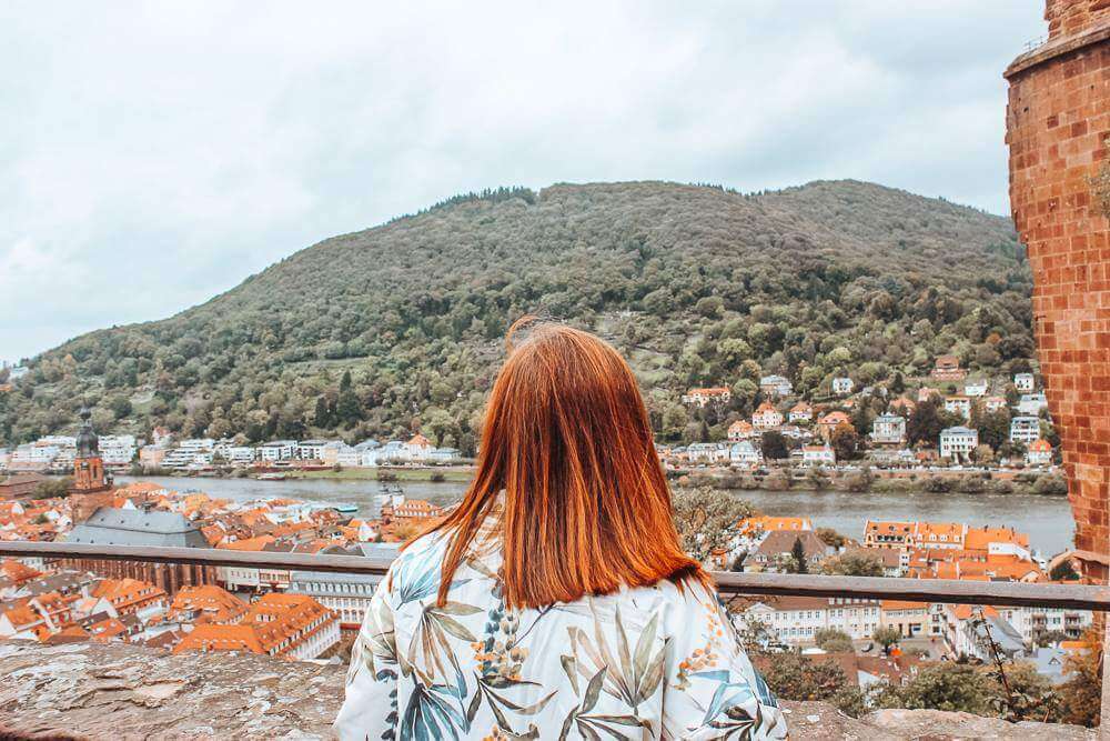 Woman looking out at Heidelberg city from Heidelberg castle one of the best things to do in 1 day in Heidelberg