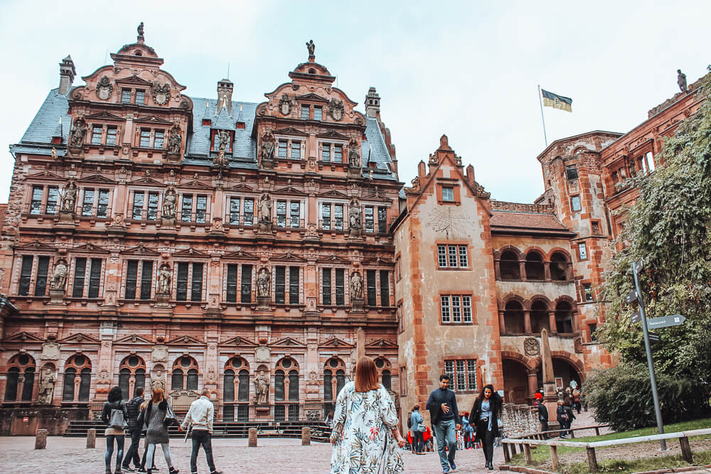 Woman looking up at the ornate Heidelberg castle a wonderful thing to do in Heidelberg city