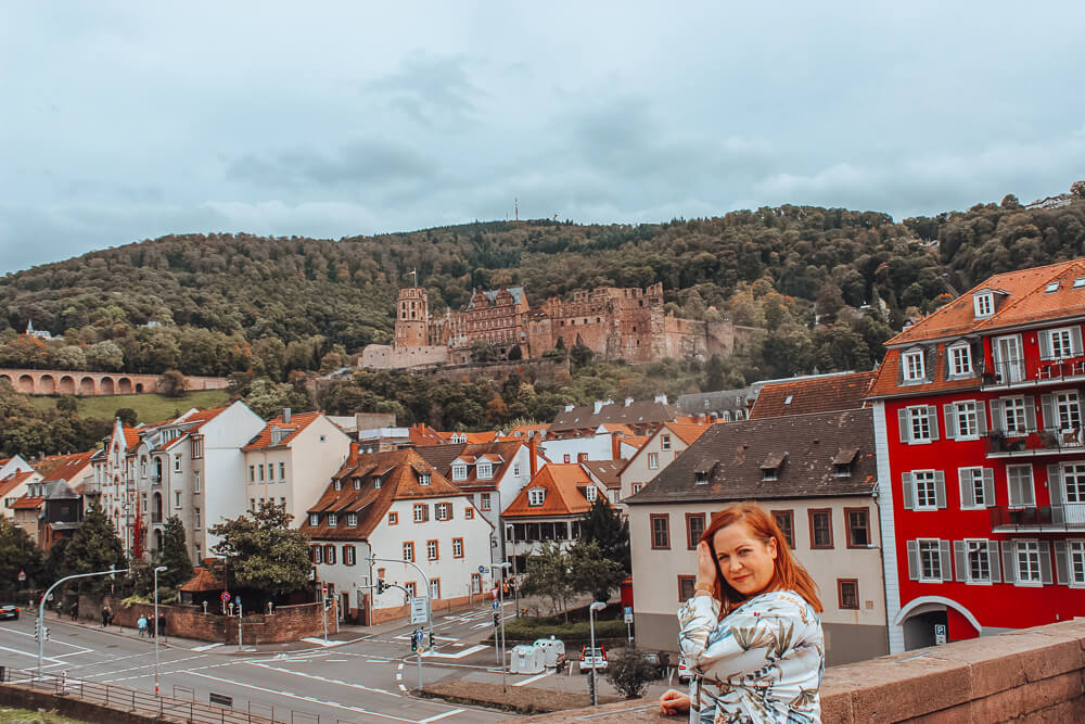 Woman standing on the alte brucke in Heidelberg Germany the perfect way to spend 1 day in Heidelberg Germany