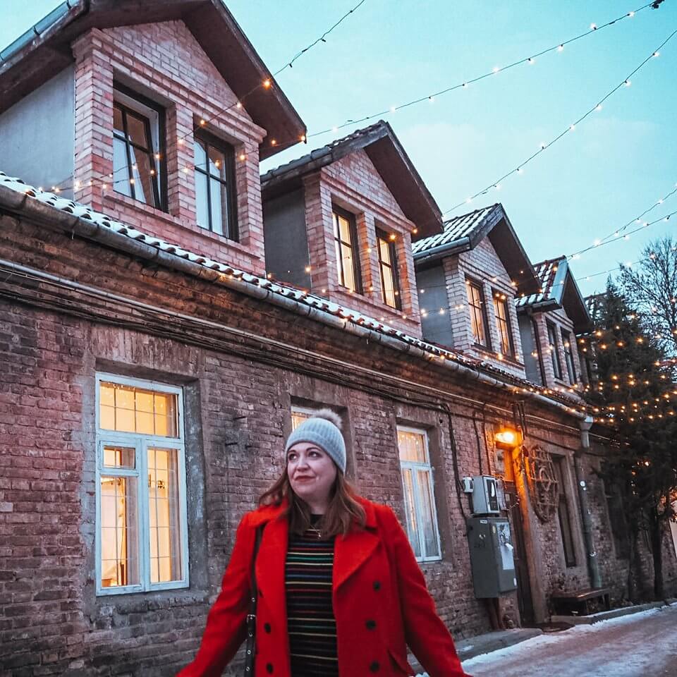 Woman in a red coat exploring the streets of Vilnius