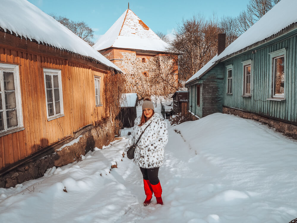 Woman in red boots standing in the snow in Trakai Lithuania