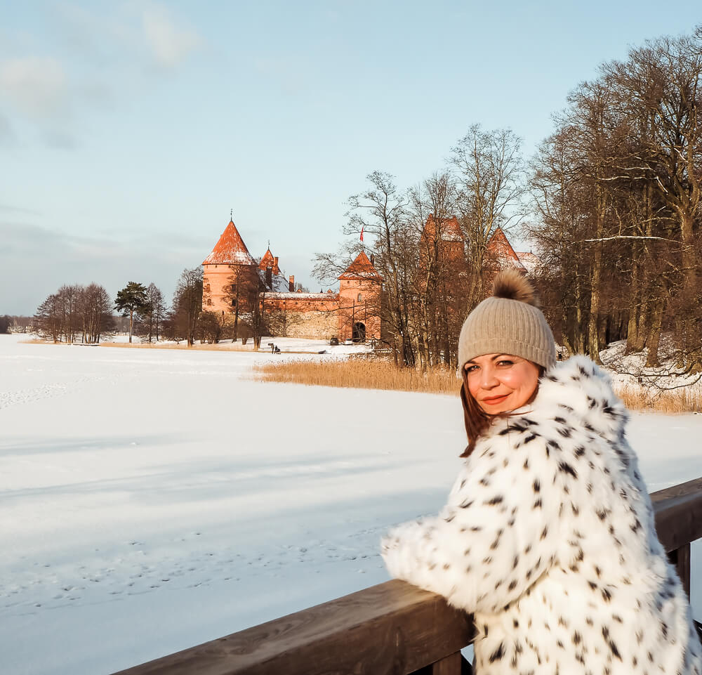 Woman looking at the frozen lake at Traki Castle in Lithuania