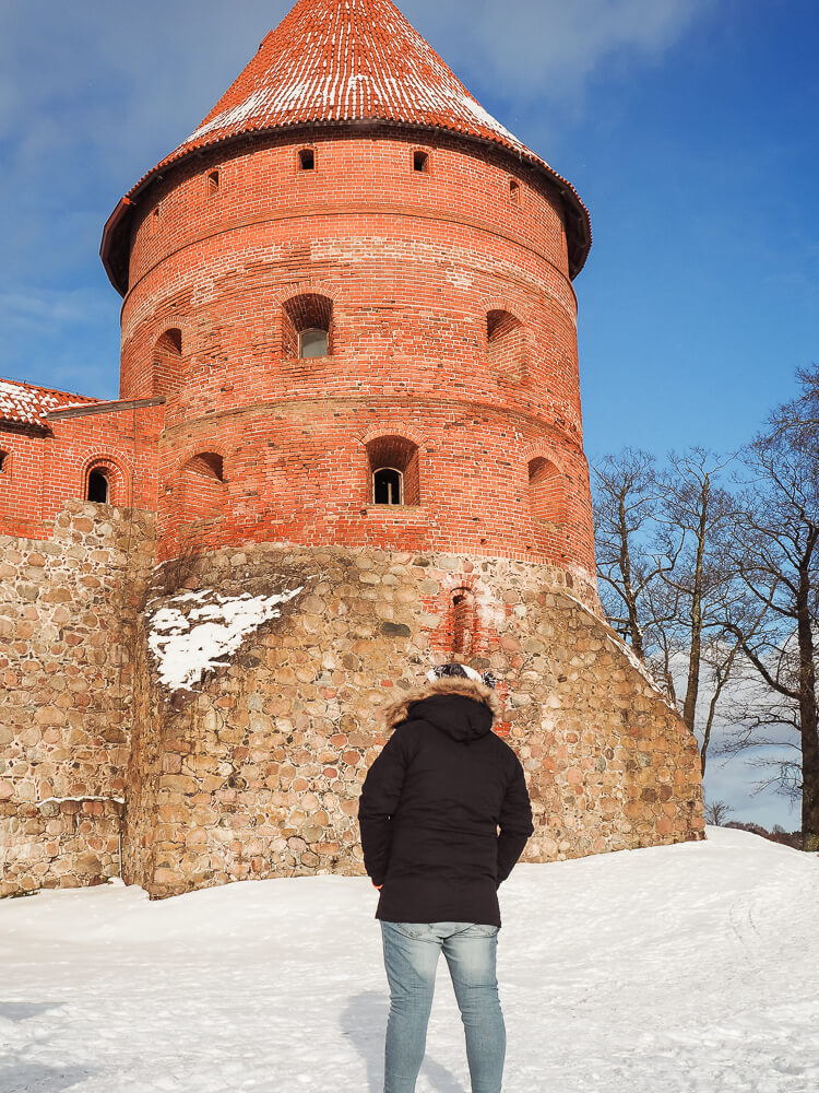 Man standing outside Trakai Island Castle in Lithuania