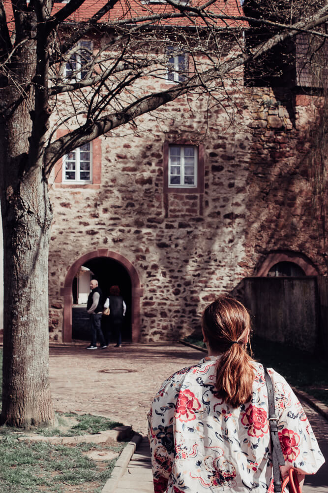Woman with red hair walking through the city walls of Michelstadt