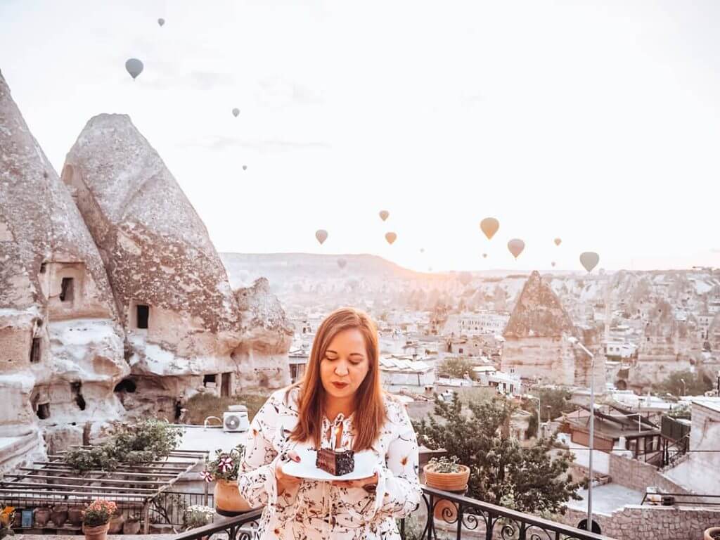 Woman blowing out candles on her birthday cake in Cappadocia Turkey