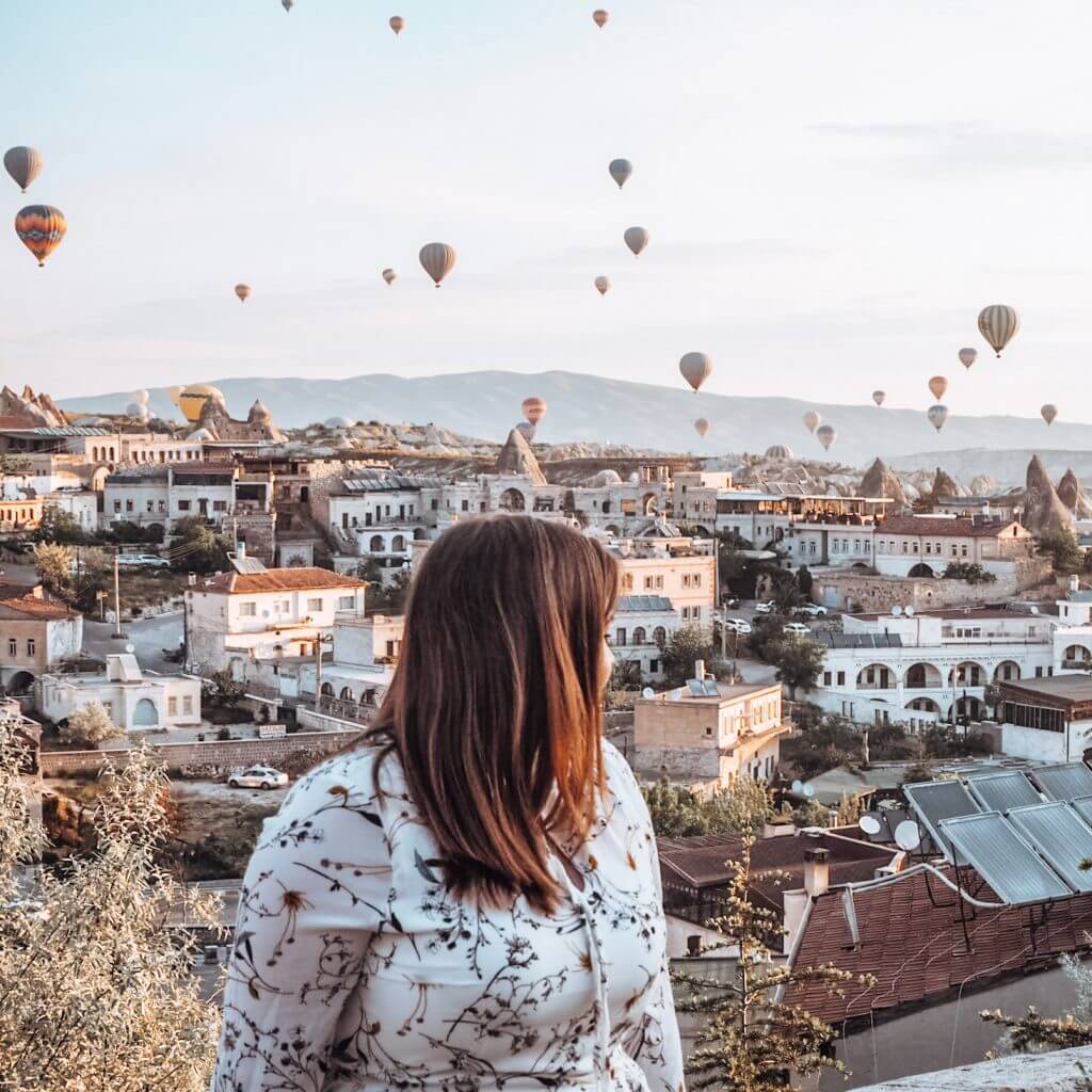 Women watching the hot air ballons rise over Goreme in Cappadocia Turkey