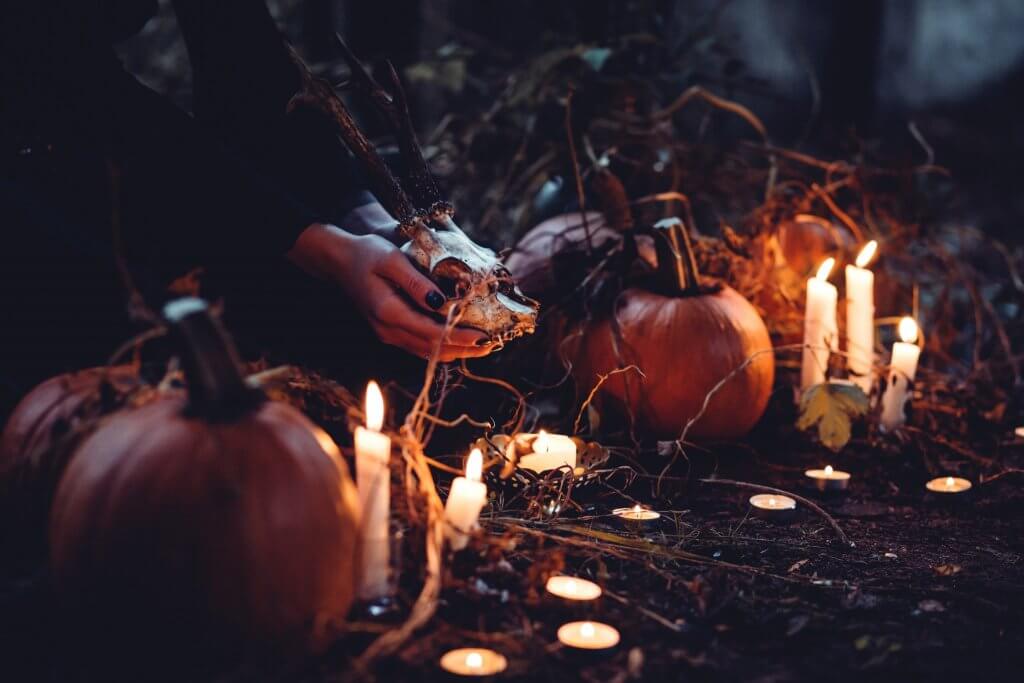 Woman lighting candles surrounded by pumpkins at Halloween in Ireland