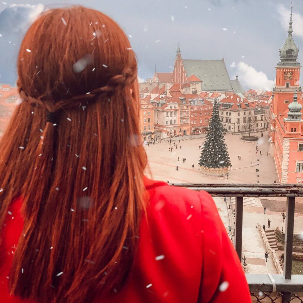 Woman in a red coat looking down at the main palace square from St Anne's observatory