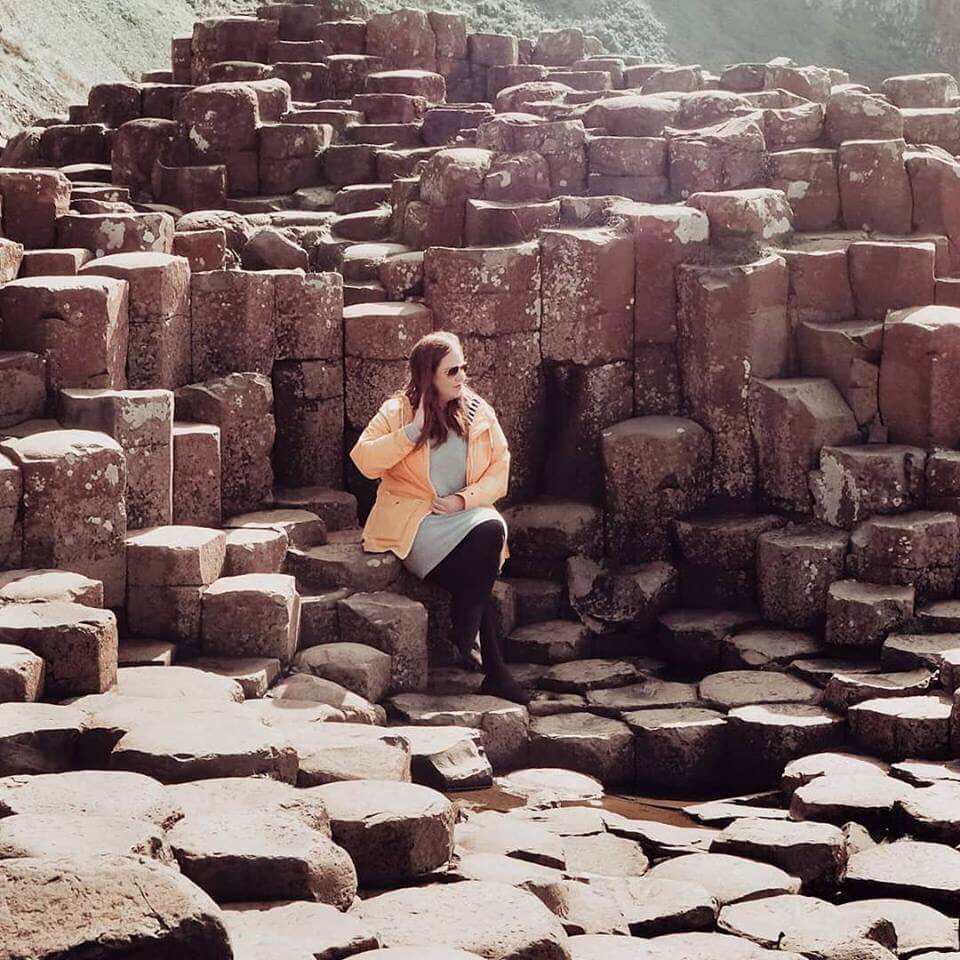 girl sitting on rock at Giant's causeway Northern Ireland