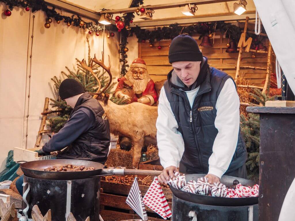 Two men roasting chestnuts at Hamburg Christmas market