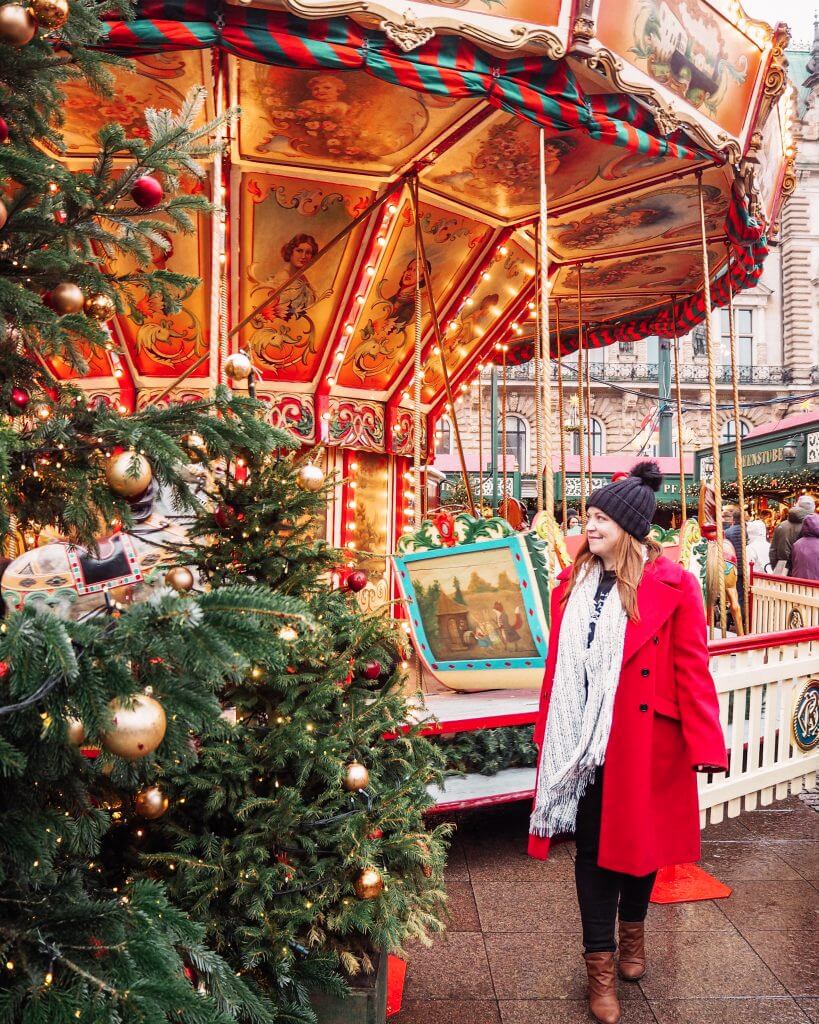 Girl in a red coat at a christmas carousel at the Hamburg Christmas markets