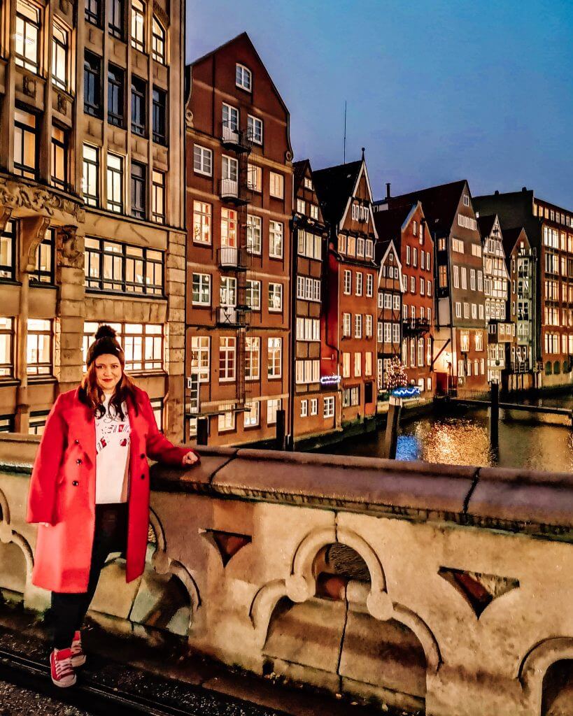 girl in red coat standing on at bridge at Deichstraße Hamburg Germany