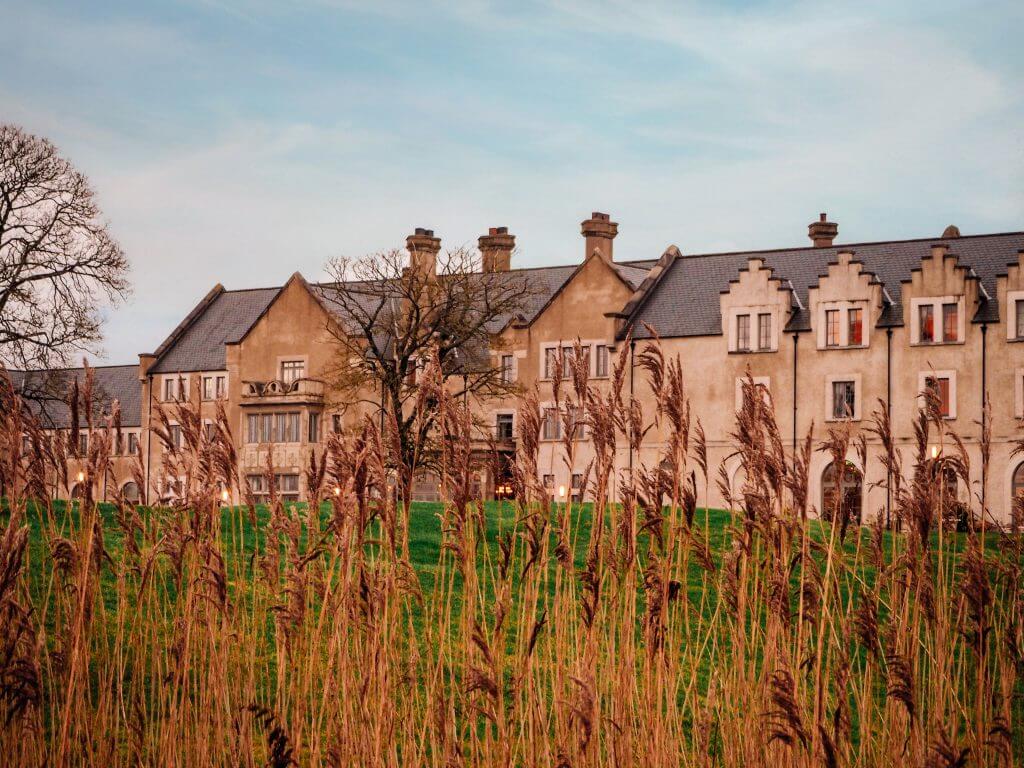 Hotel building of Lough Erne resort viewed through the reeds of Castle Hume Lough lakeshore