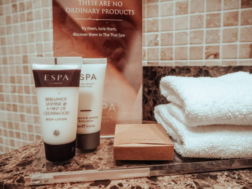 Bathroom counter with ESPA toiletries and folded towels.