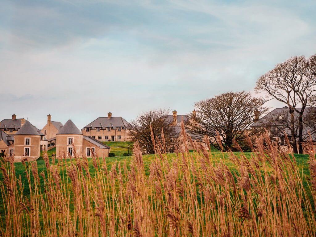 Hotel buildings and lodges of Lough Erne golf and spa resort seen through the redds of the lakeshore of Lough Hume.