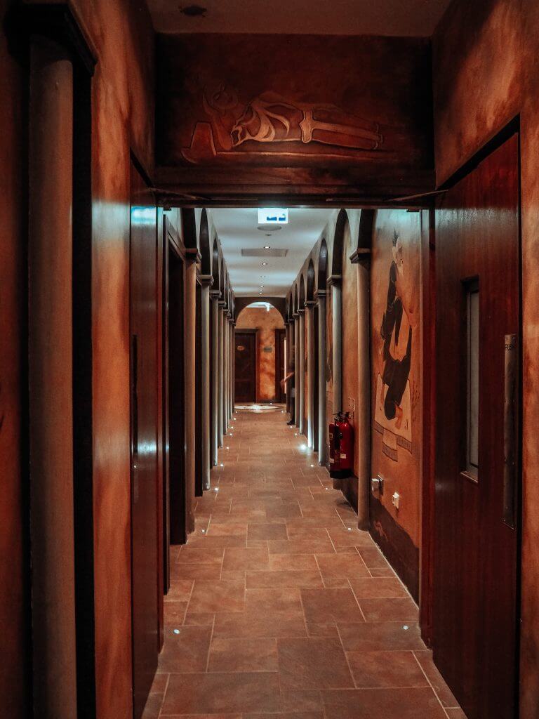 Corridor of dark wood paneling containing the treatment rooms at The Thai Spa in one of Ireland's most luxurious hotels.