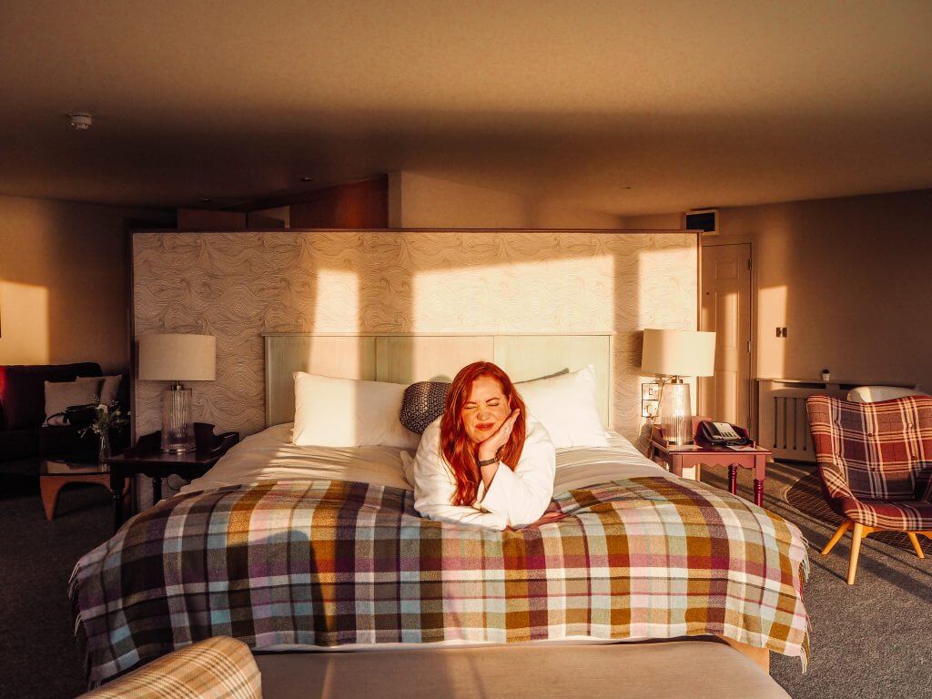 Woman lying on her bed in a hotel room in County Clare Ireland for an Instagram brand collaboration