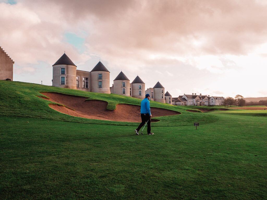 Man in a blue top walking The Nick Faldo golf course at Lough Erne