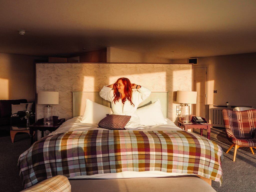 Woman stretching in a hotel bed at Armada Spanish Point Hotel Ireland
