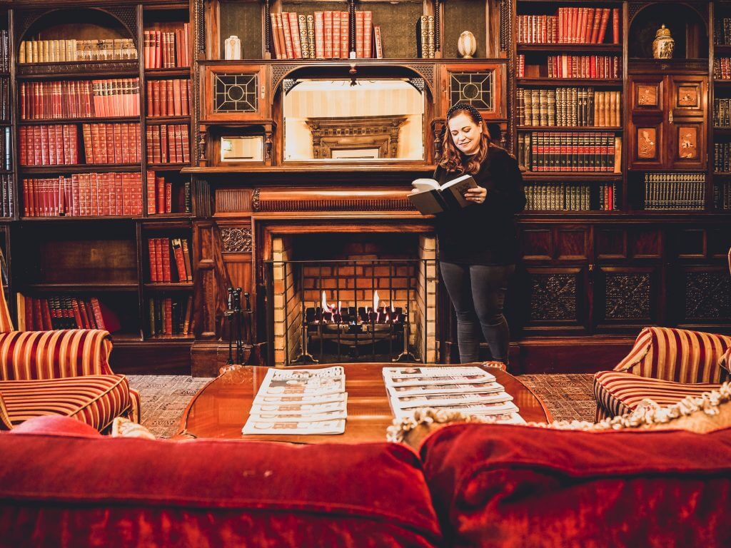 Female hotel guest reading in the library of Lough Erne resort.