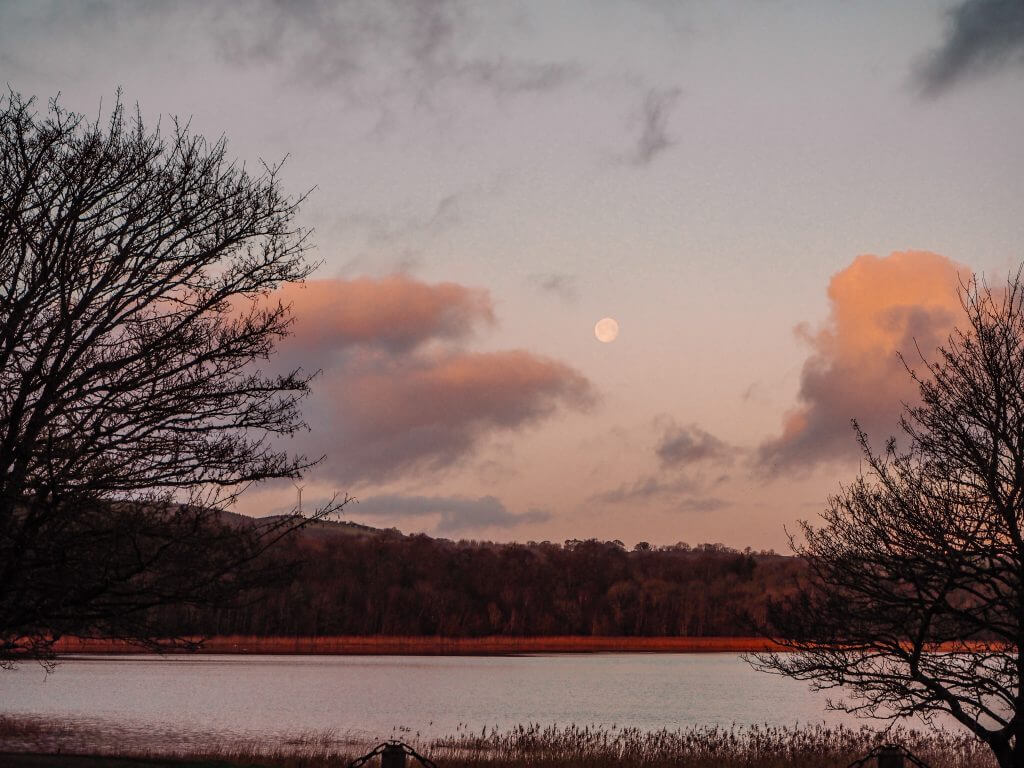 Early morning views over Castle Hume Lough with the moon still visible in the sky.