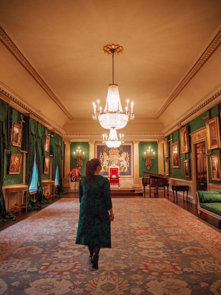 Woman in a green dress walking in the throne room of Hillsborough Castle in Northern Ireland