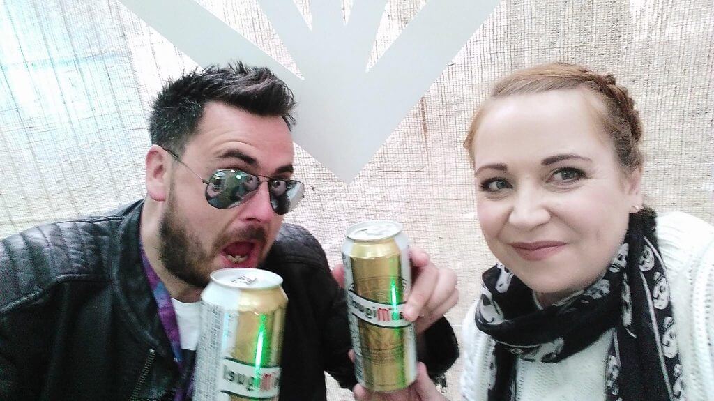 Couple drinking a can of beer at a music festival