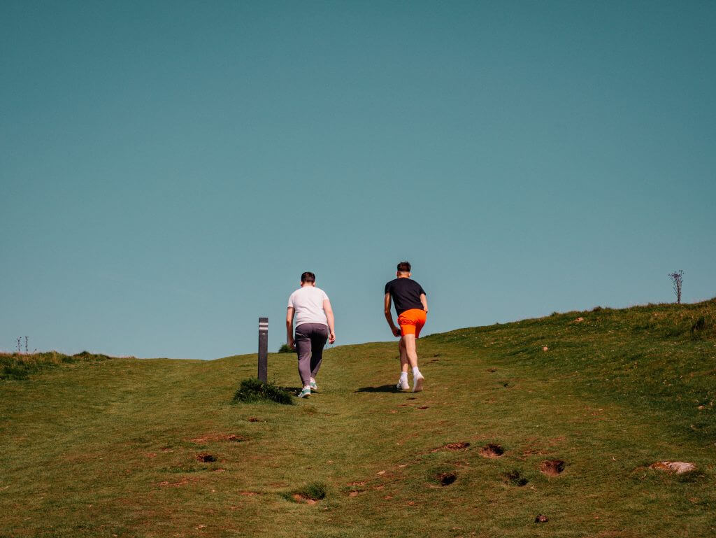 Two boys climbing up the steep incline at Loughcrew Cairns