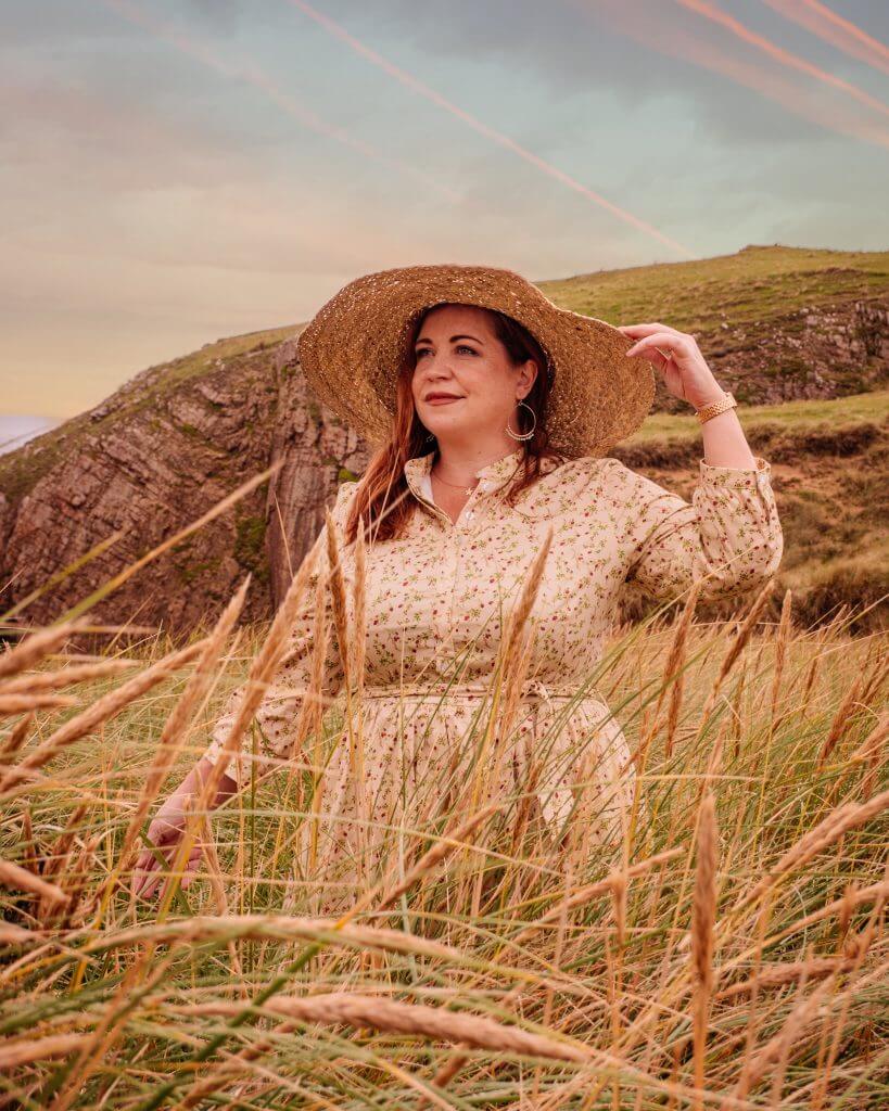 Woman in a yellow floral dress and straw hat enjoying her staycation in Ireland