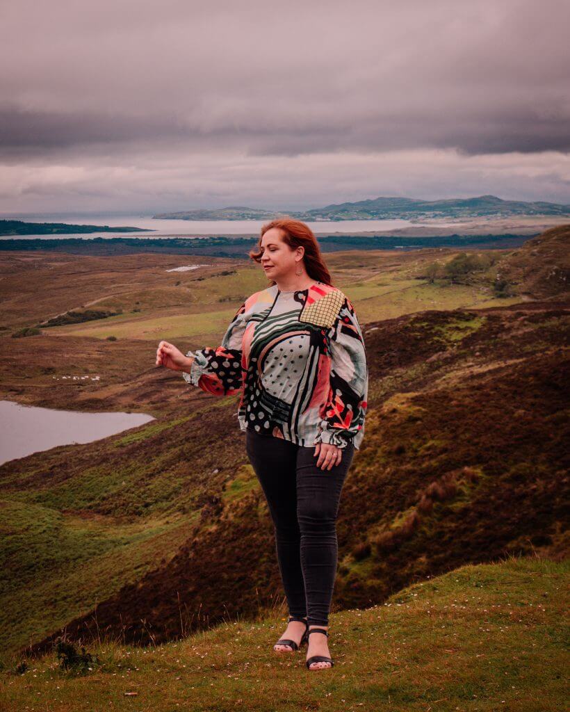 Woman in a colourful top overlooking the views of the Wild Atlantic Way in Donegal