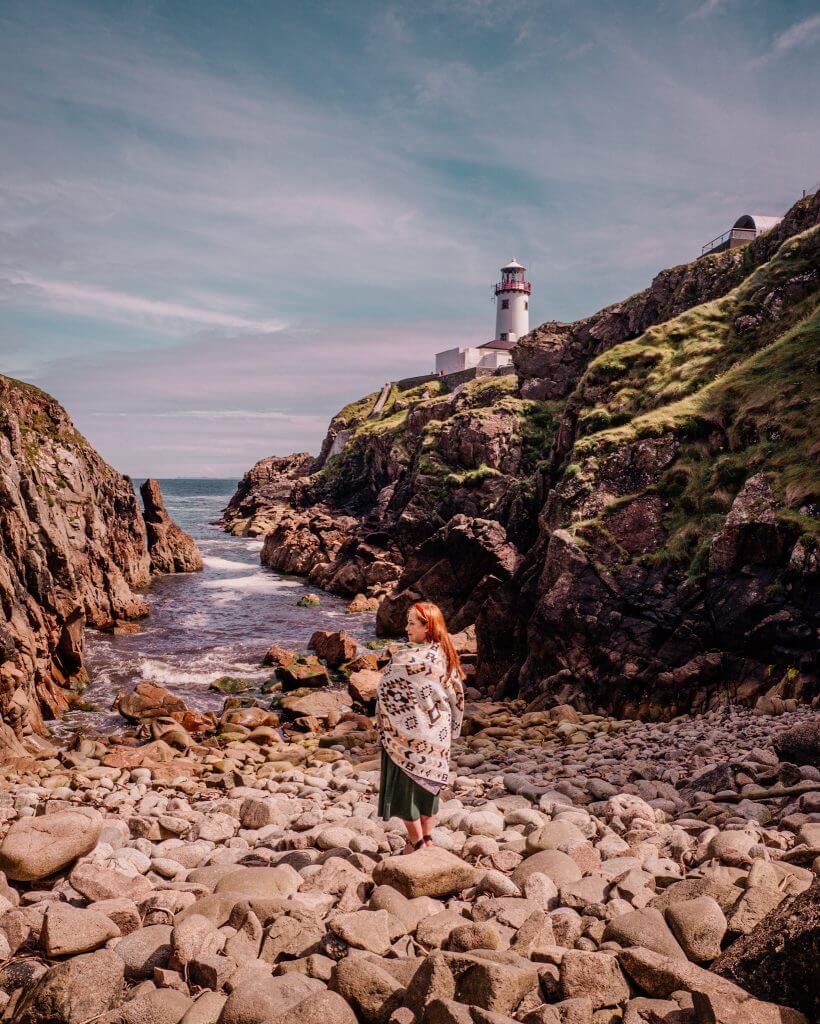 Woman standing by the shoreline at Fanad Head Lighthouse in Donegal