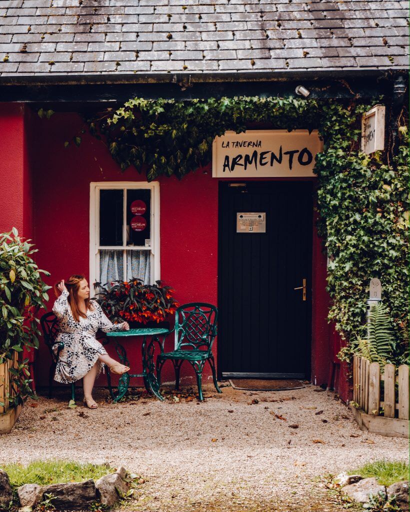 Woman sitting outside La Taverna Armento Italian restaurant at Brooklodge
