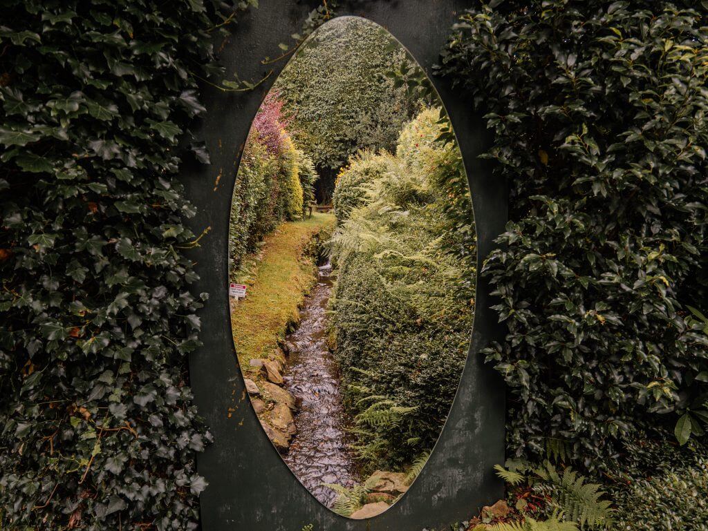 Mirror reflecting a beautiful stream at Shekina Sculpture Garden in Wicklow Ireland