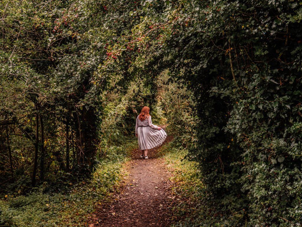 Girl walking in the woods in the wicklow mountains on her staycation in Ireland.