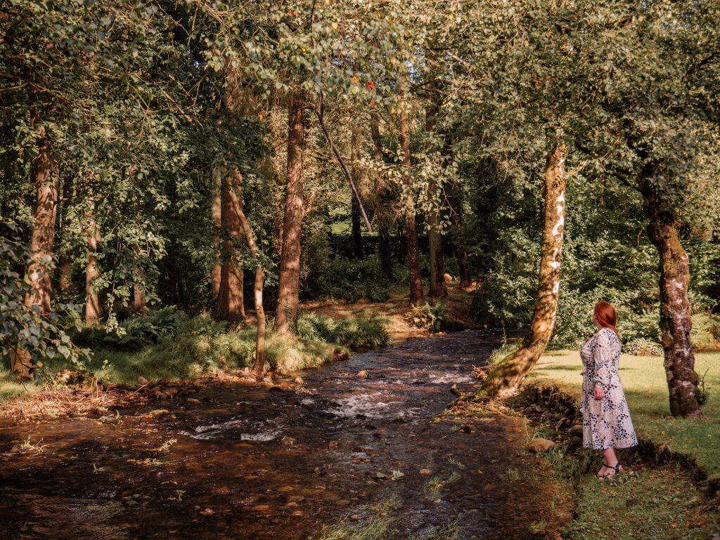 Woman walking beside a brook at Brooklodge Hotel in Wicklow
