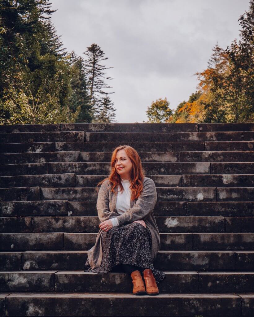Woman sitting on stone steps at Ashford Castle in Ireland