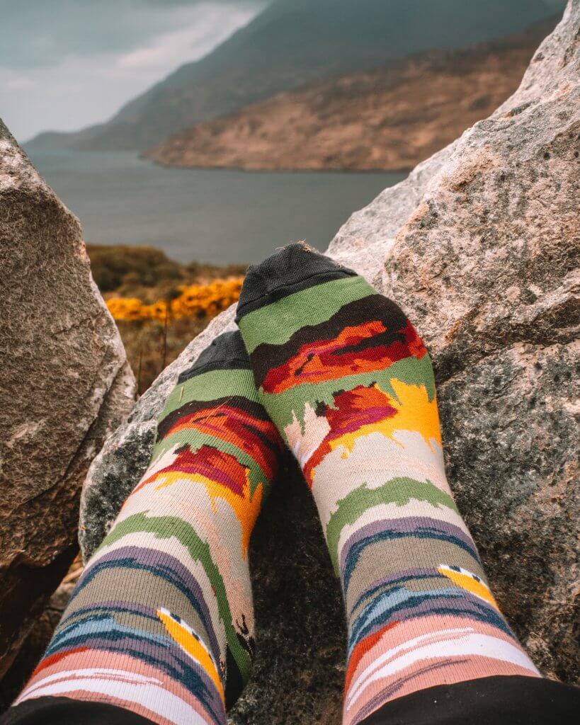 Feet wearing Connemara socks with the backdrop of Killary fjord