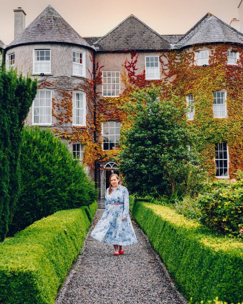 Woman in a blue dress walking around the gardens of Butler House Kilkenny