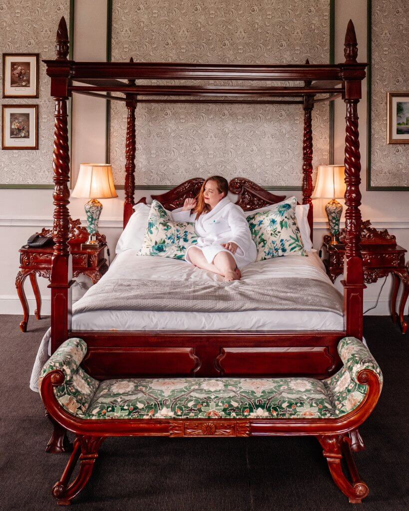 Woman lying on a four poster bed in a manor room at the Lyrath Estate and spa on a weekend in Kilkenny