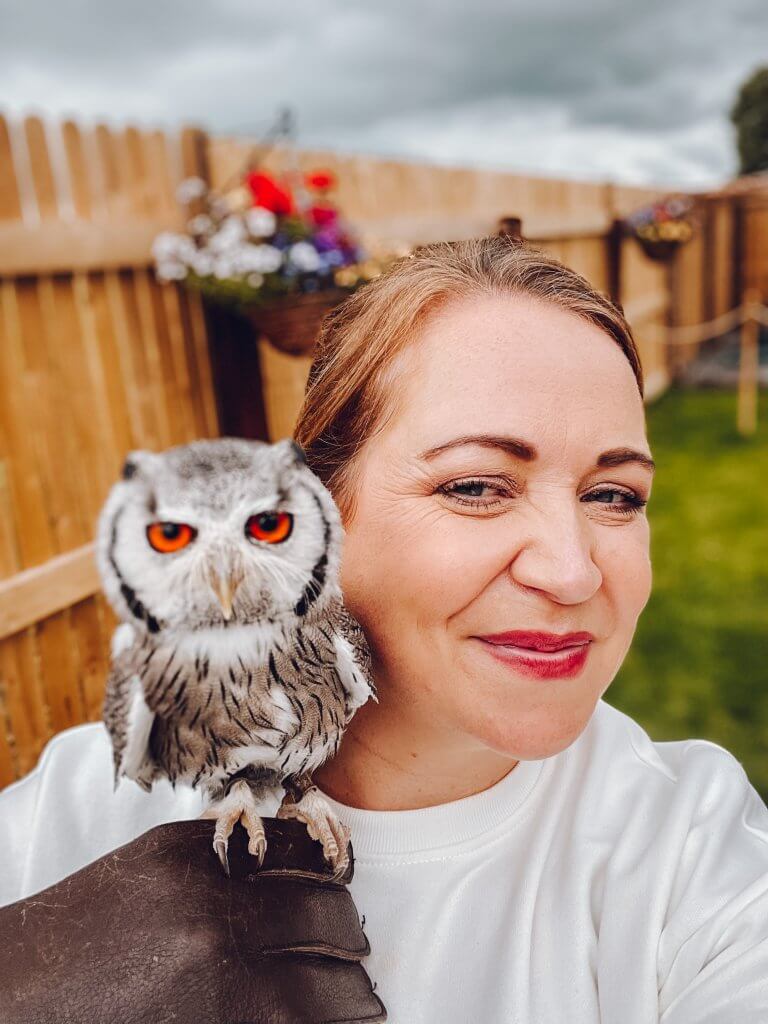 Woman getting an owl selfie with a south african white faced owl