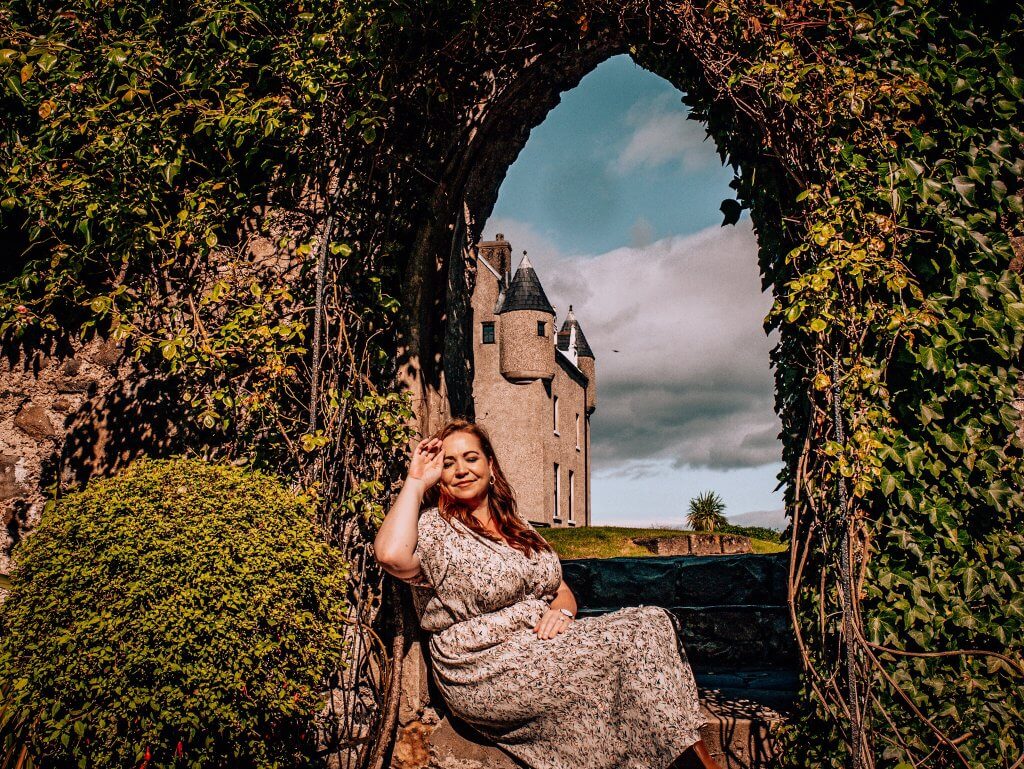 Woman soaking up the sun in a garden archway at Ballygally Castle Hotel in County Antrim Northern Ireland