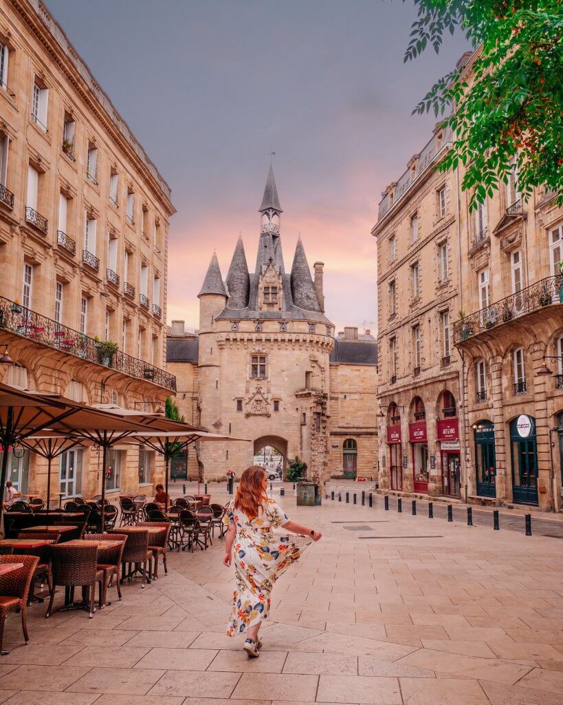 Woman standing in front of Porte Cailhau one of the best Instagram spots in Bordeaux