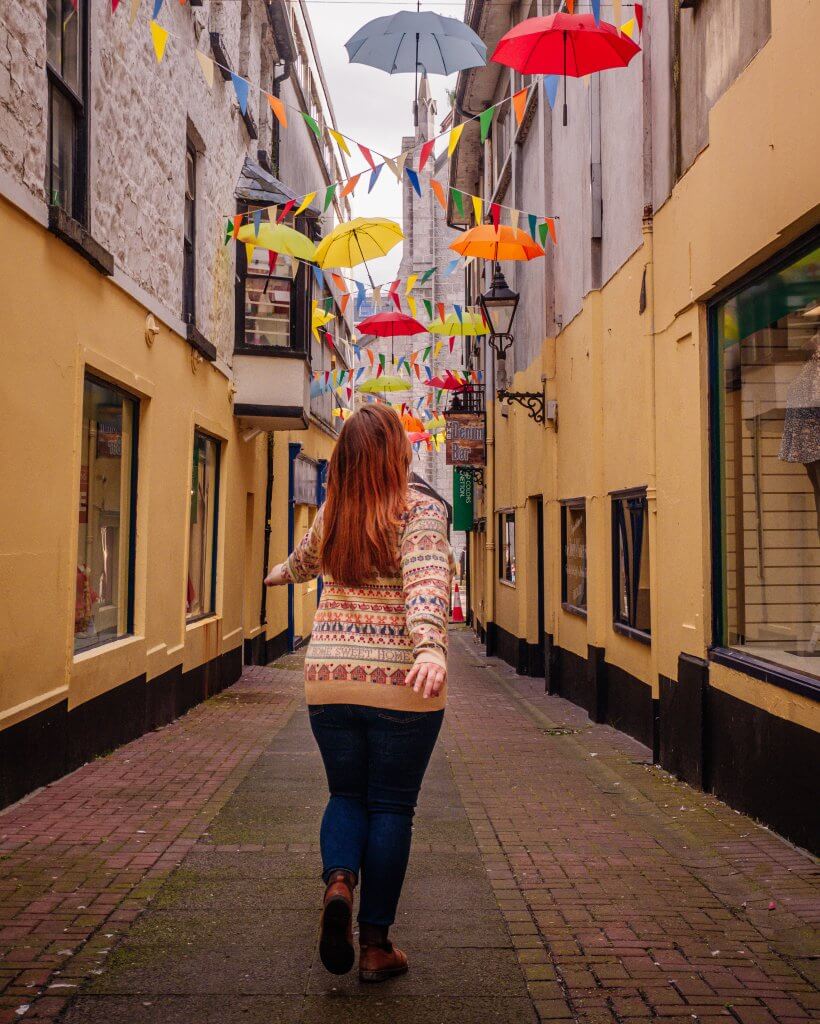Woman walking under an umbrella sky on a weekend break in Galway Ireland