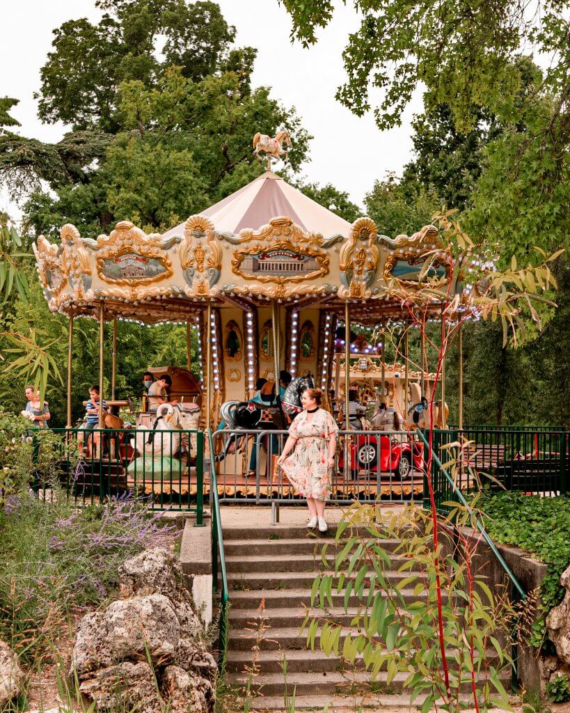 Woman looking at the carousel in the Jardin Public in Bordeaux which is a must see place to put on your Bordeaux itinerary