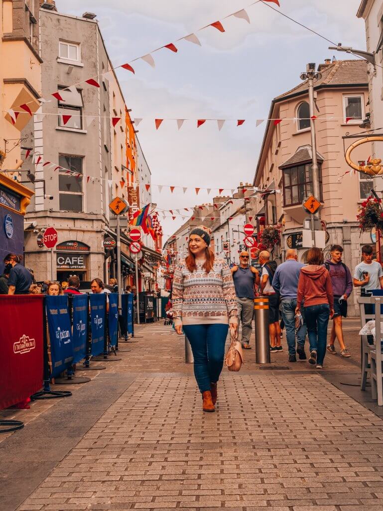 Woman walking along the Latin Quarter on a weekend break in Galway city Ireland
