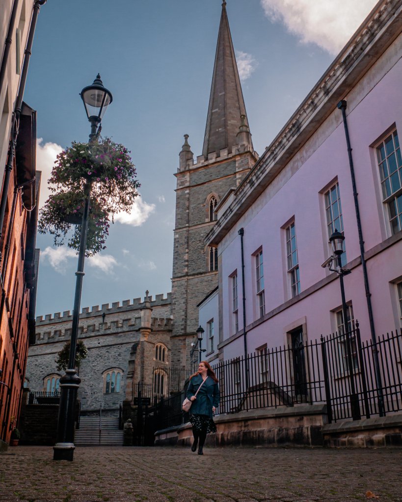 Woman in a blue coat exploring Derry in Northern Ireland