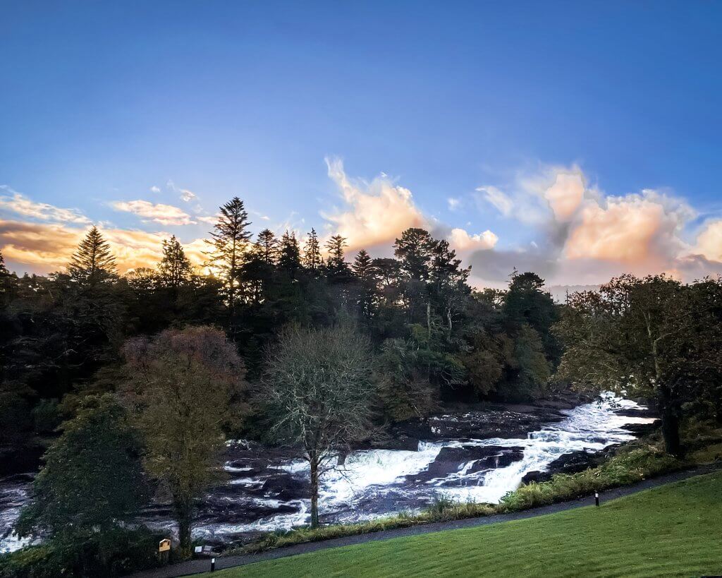 Spectacular sunrise at Sheen Falls Lodge, casting a golden glow over the tranquil countryside.