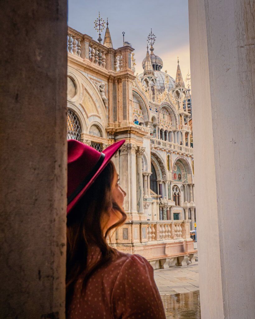 Woman in a red hat looking out over St Mark's Square in Venice Italy a famous Instagram Spot