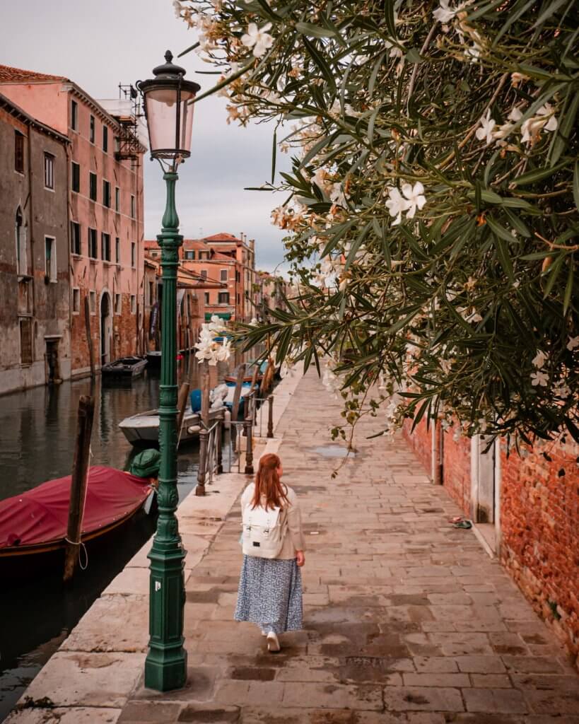 Woman walking along a canal in Cannaregio Venice