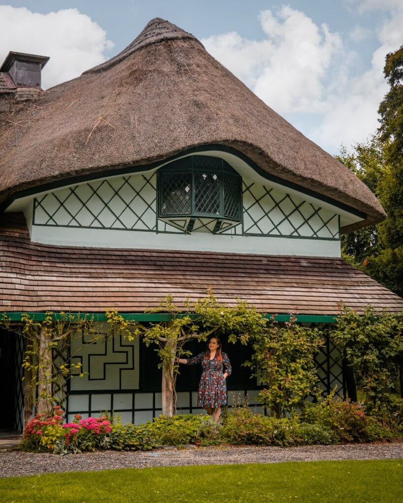 Exterior of an ornate thatch cottage covered in rosess known as Swiss Cottage in Cahir County Tipperary Ireland